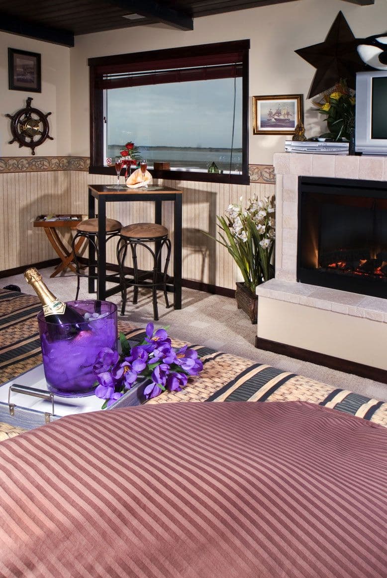 Living area with fireplace, nautical decor, and a window with a view of the waterfront.