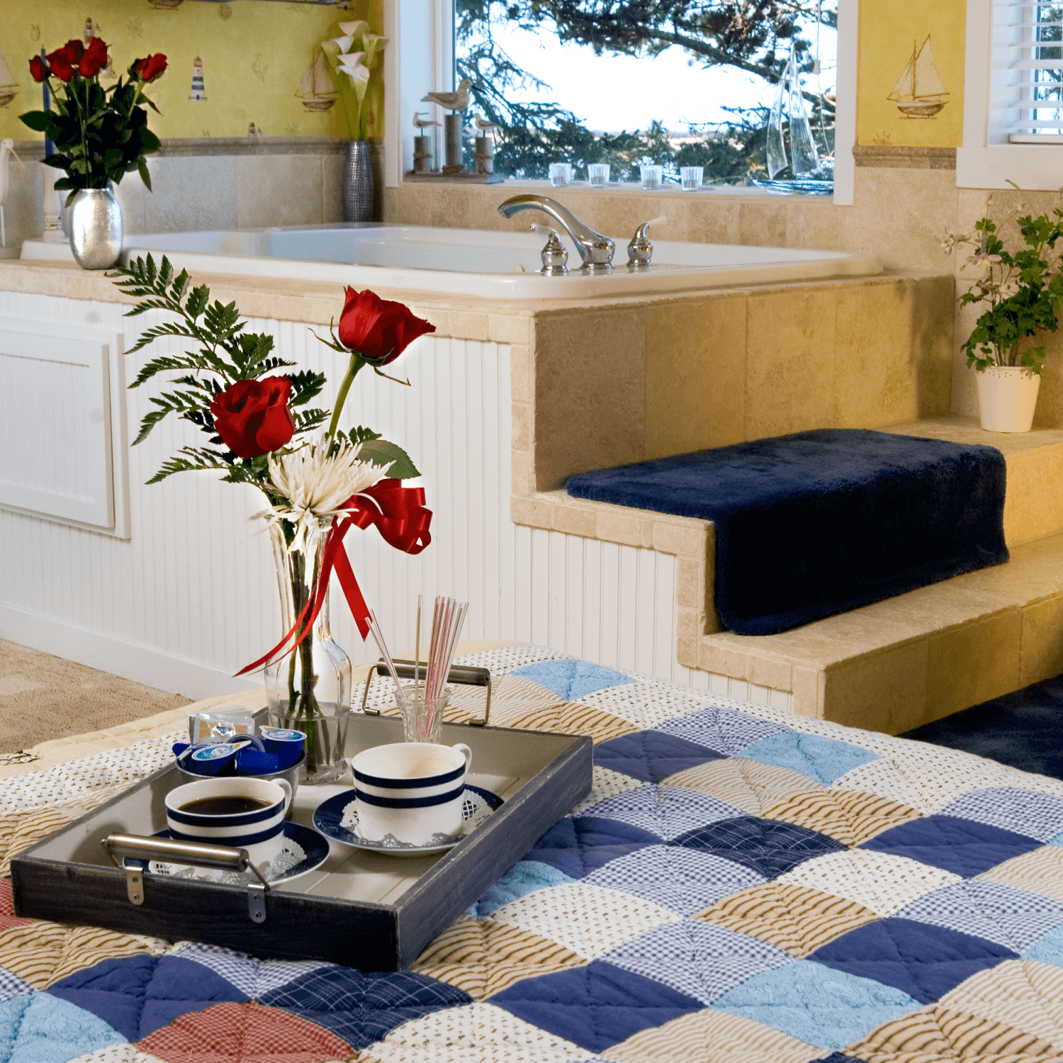A cozy bathroom scene featuring a tray with coffee and flowers near a luxurious bathtub.